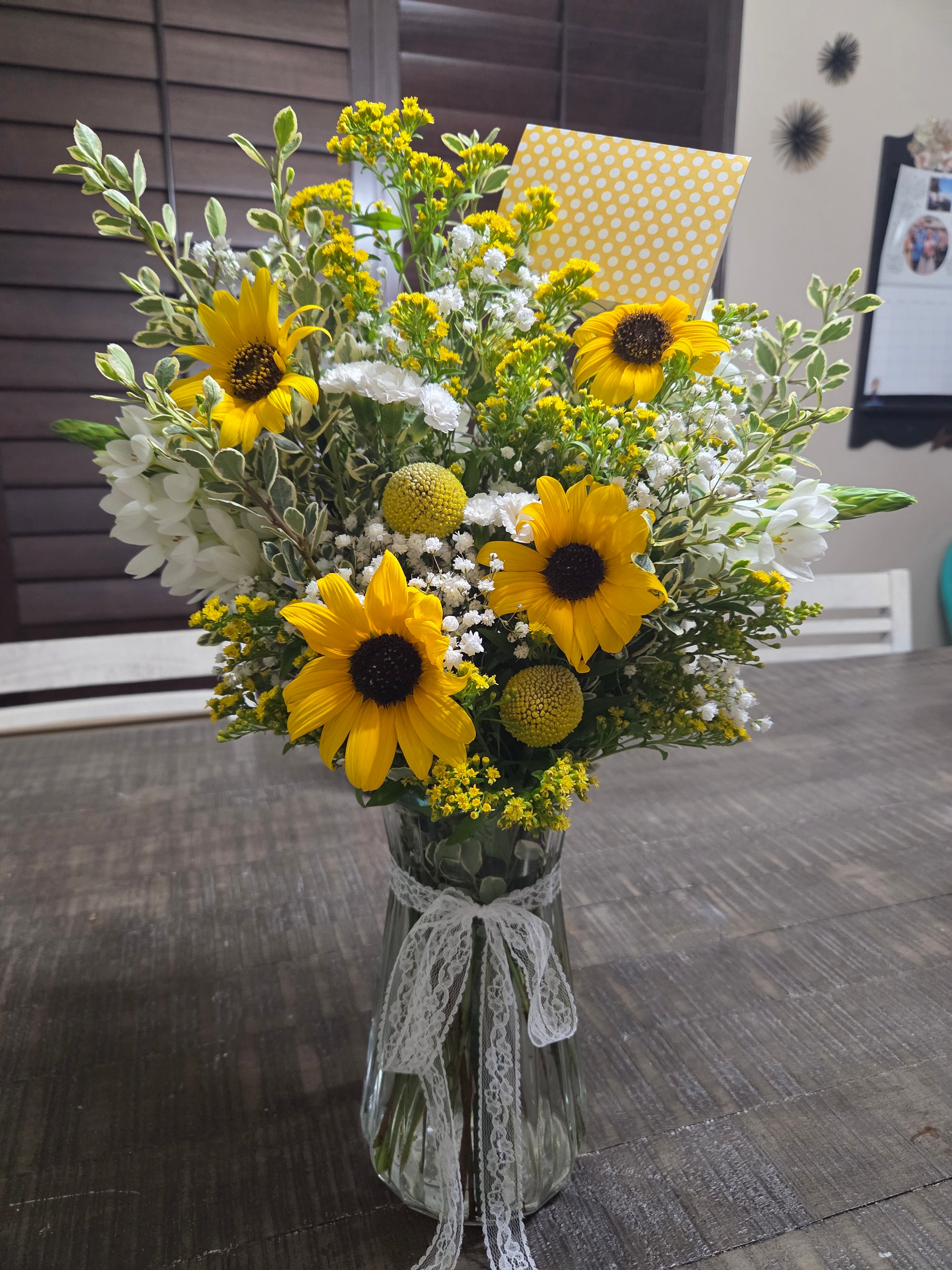 Sunflower bouquet with white flowers and lace wrapping.