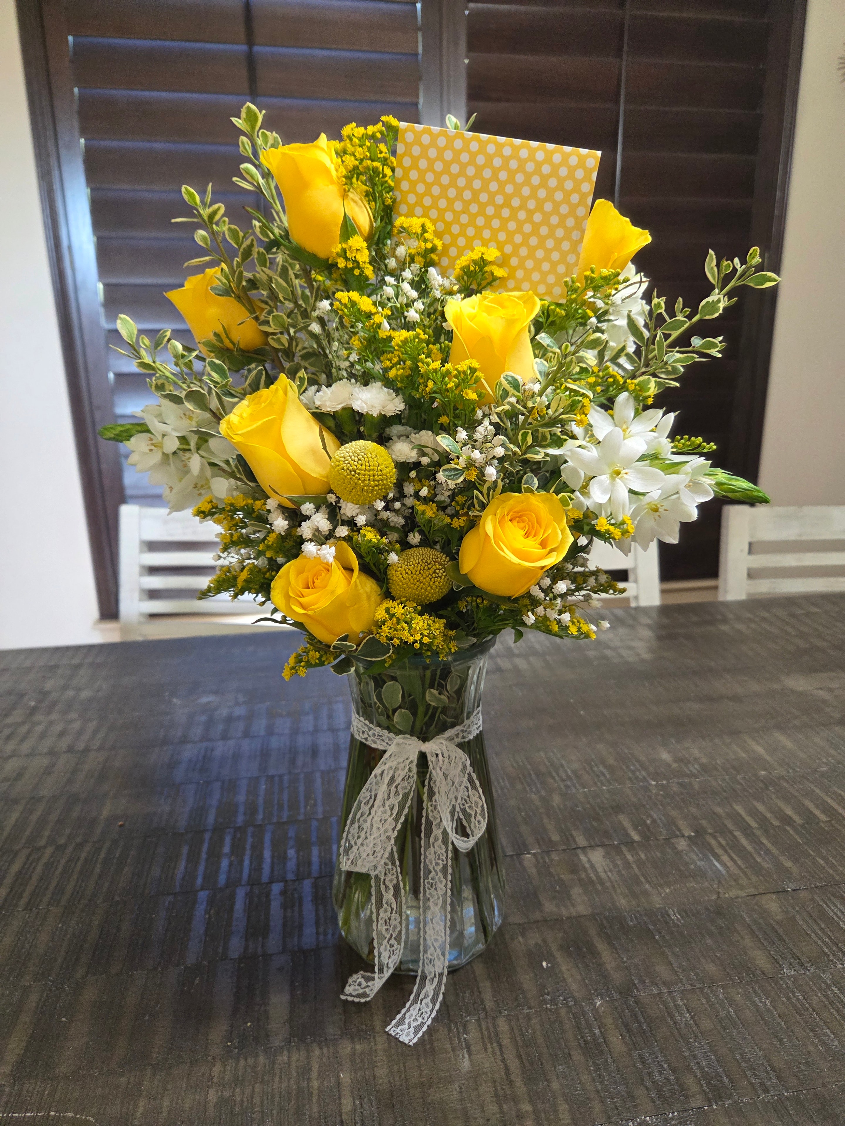 Yellow rose bouquet with white flowers and delicate lace wrapping.